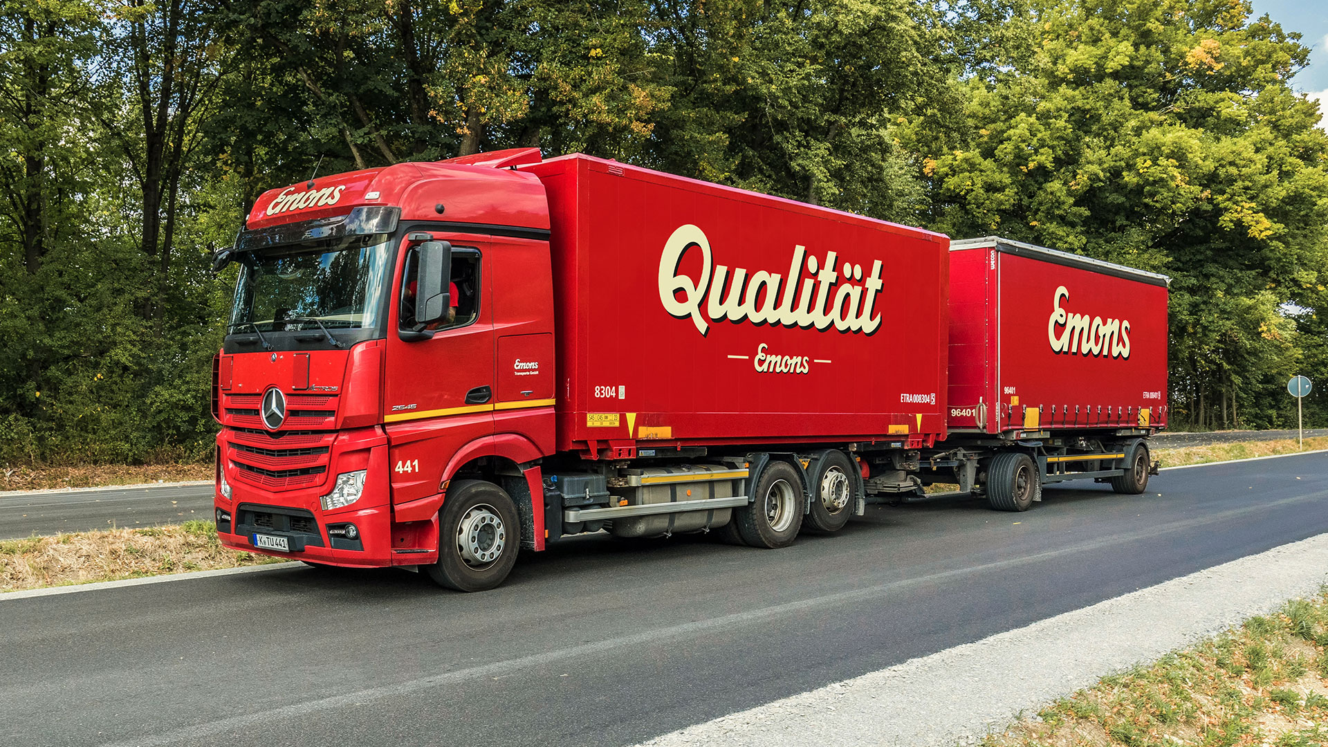 Roter Truck im Grünen mit der Aufschrift "Qualität"